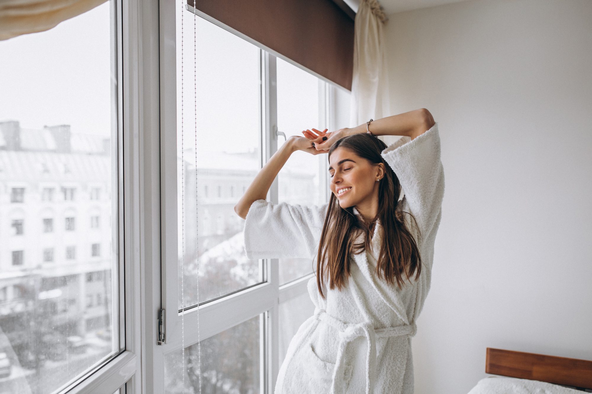 young woman morning stretching by window